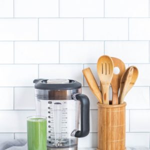 wooden spoons with blender on kitchen counter